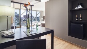 A modern hotel room with a desk, phone, decorative vase, and wine bottles. - Exe Suites Reforma (Mexico City)