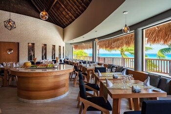 A beach with palm trees, umbrellas, and lounge chairs. at The Reef Coco Beach Resort & Spa- Optional All Inclusive