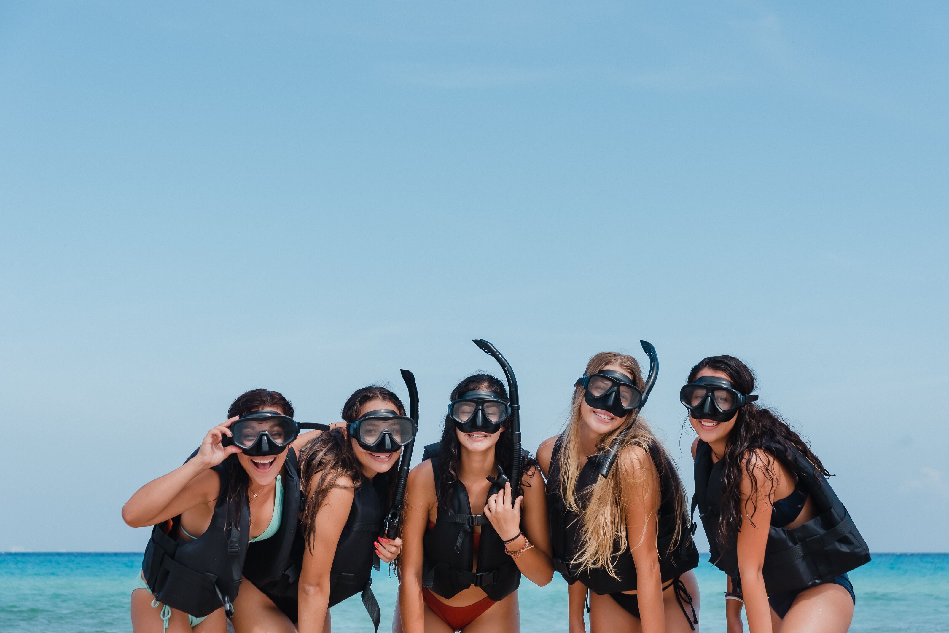 A group of people on a beach with clear skies.