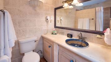 A bathroom with a toilet, sink, and mirror.