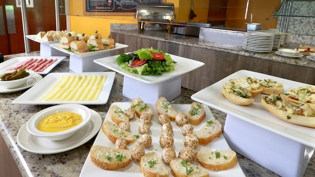 A buffet with various food items including salads, bread, and dips.