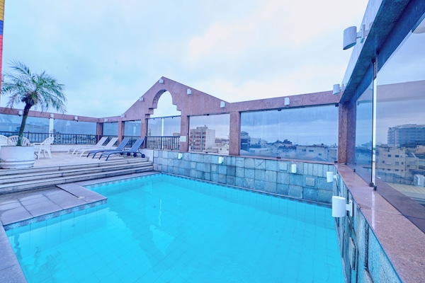 Una piscina al aire libre, tumbonas