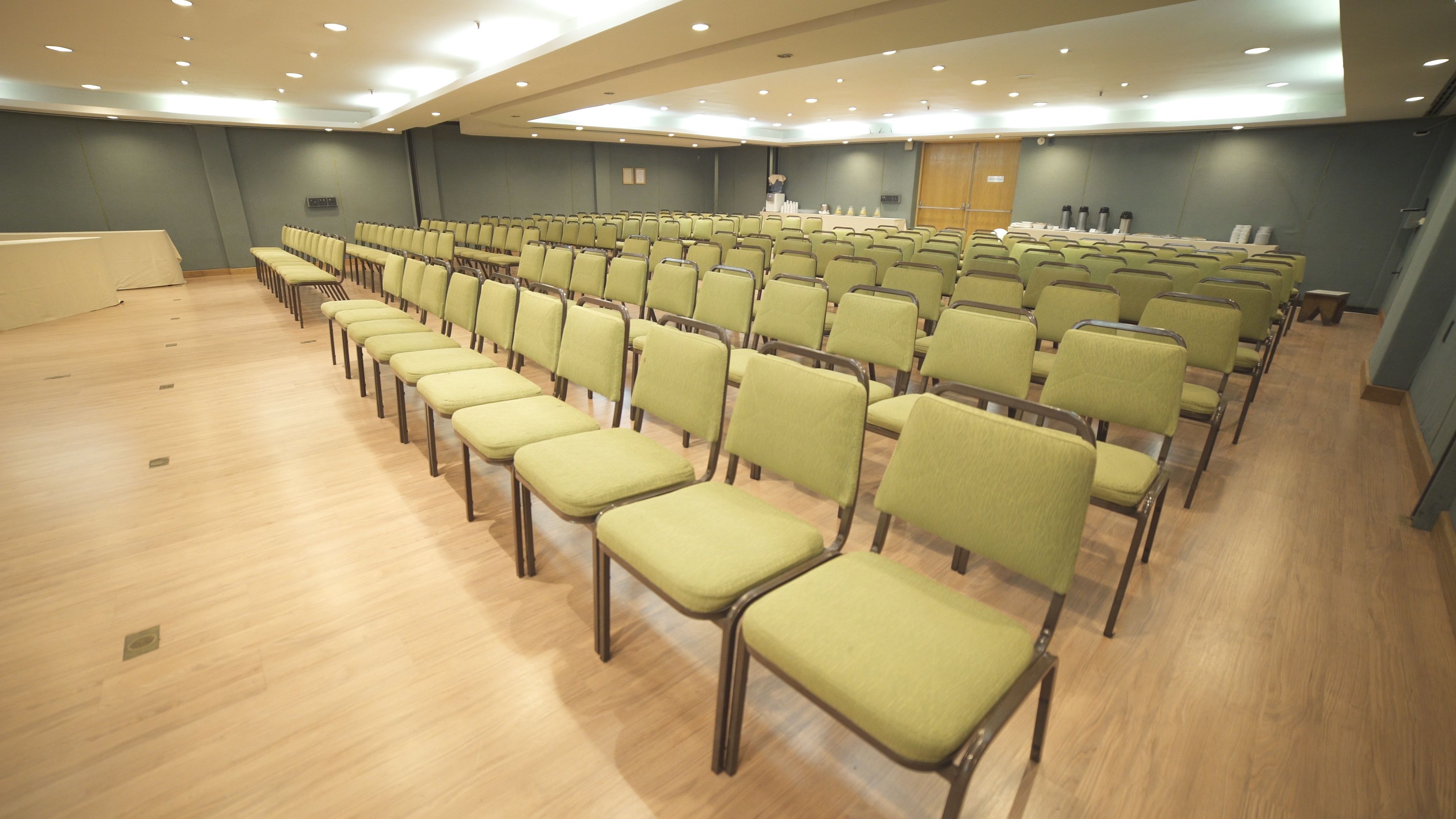Une salle de conférence avec des rangées de chaises, une scène et un pupitre.