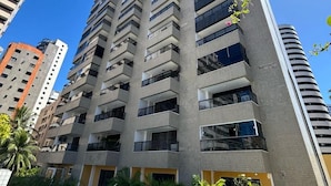 A high-rise building with a swimming pool in the foreground.