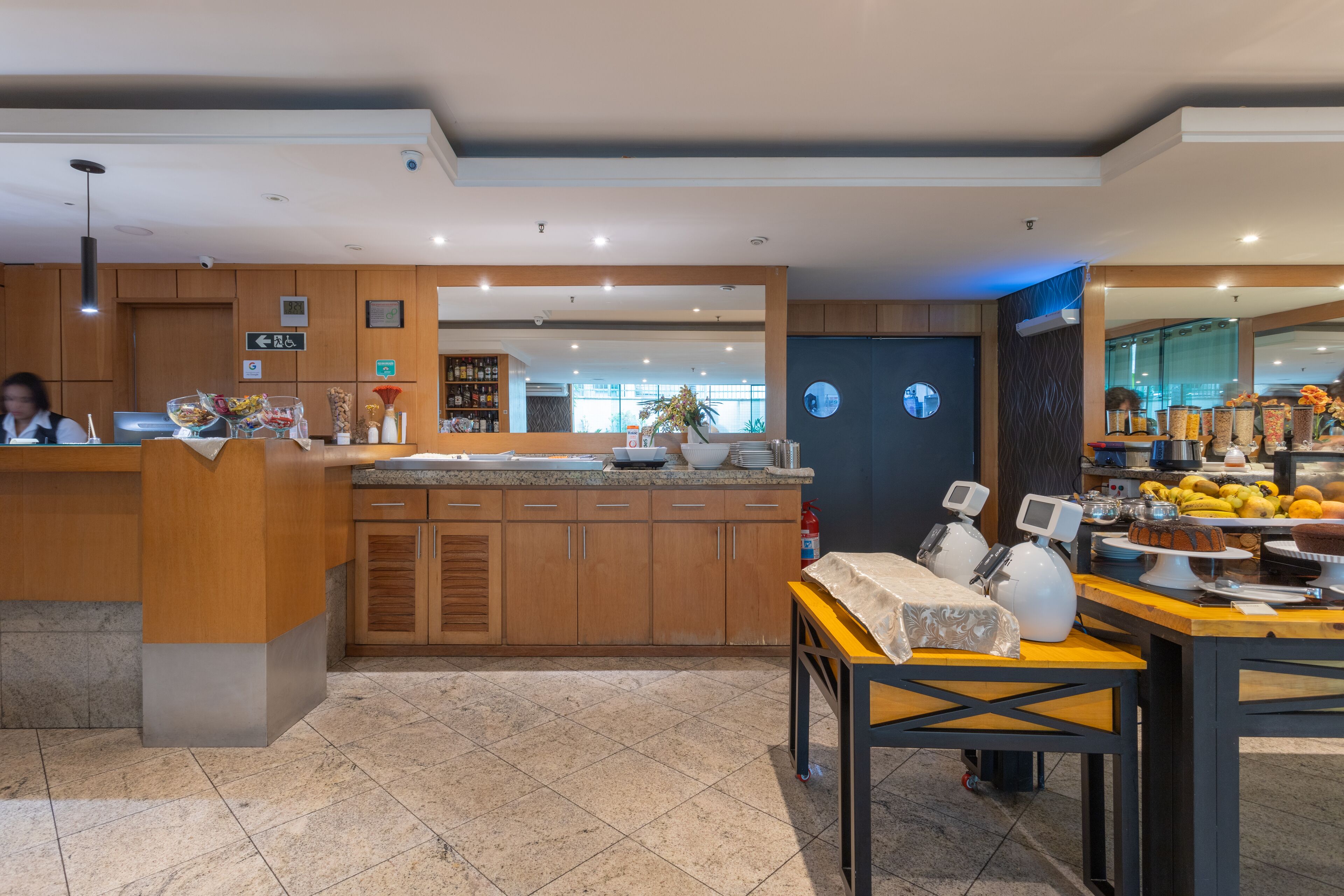 A modern kitchen with wooden cabinets, a central island, and a dining area with a table and chairs.