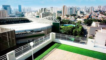 Um estádio moderno com grama sintética verde e guarda-corpo branco.