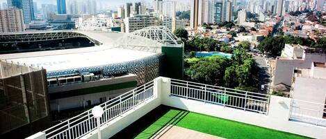 Un estadio moderno con césped artificial verde y una barandilla blanca.