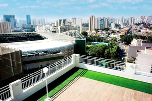 Um estádio moderno com grama sintética verde e guarda-corpo branco.