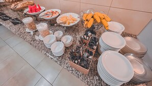 A buffet setup with various food items and dishes. - Plaza Inn Week Inn (Campos do Jordão)