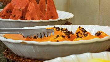 Un bufé con diversas frutas, como sandía y papaya.