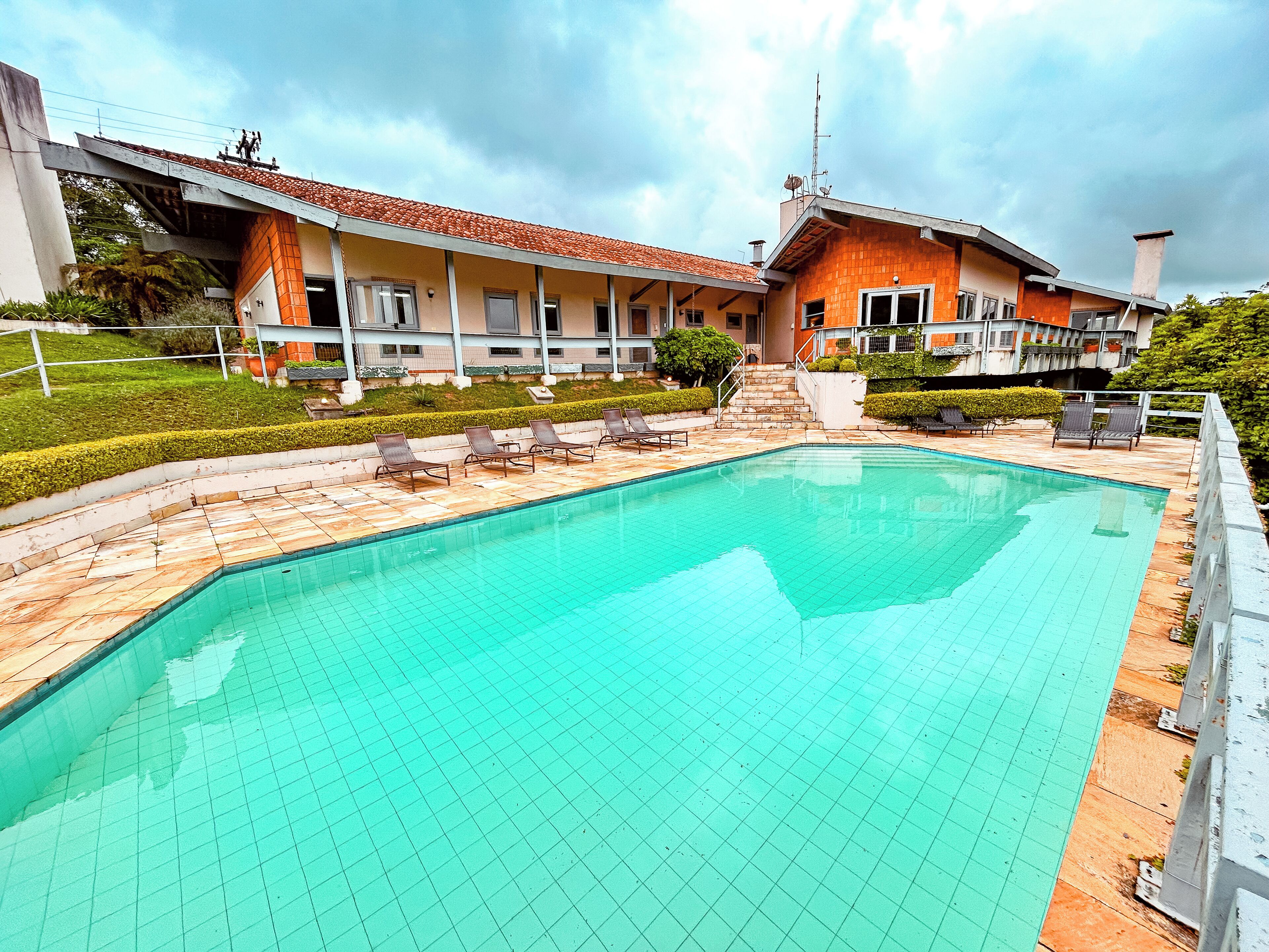 Una piscina al aire libre, sillones reclinables de piscina