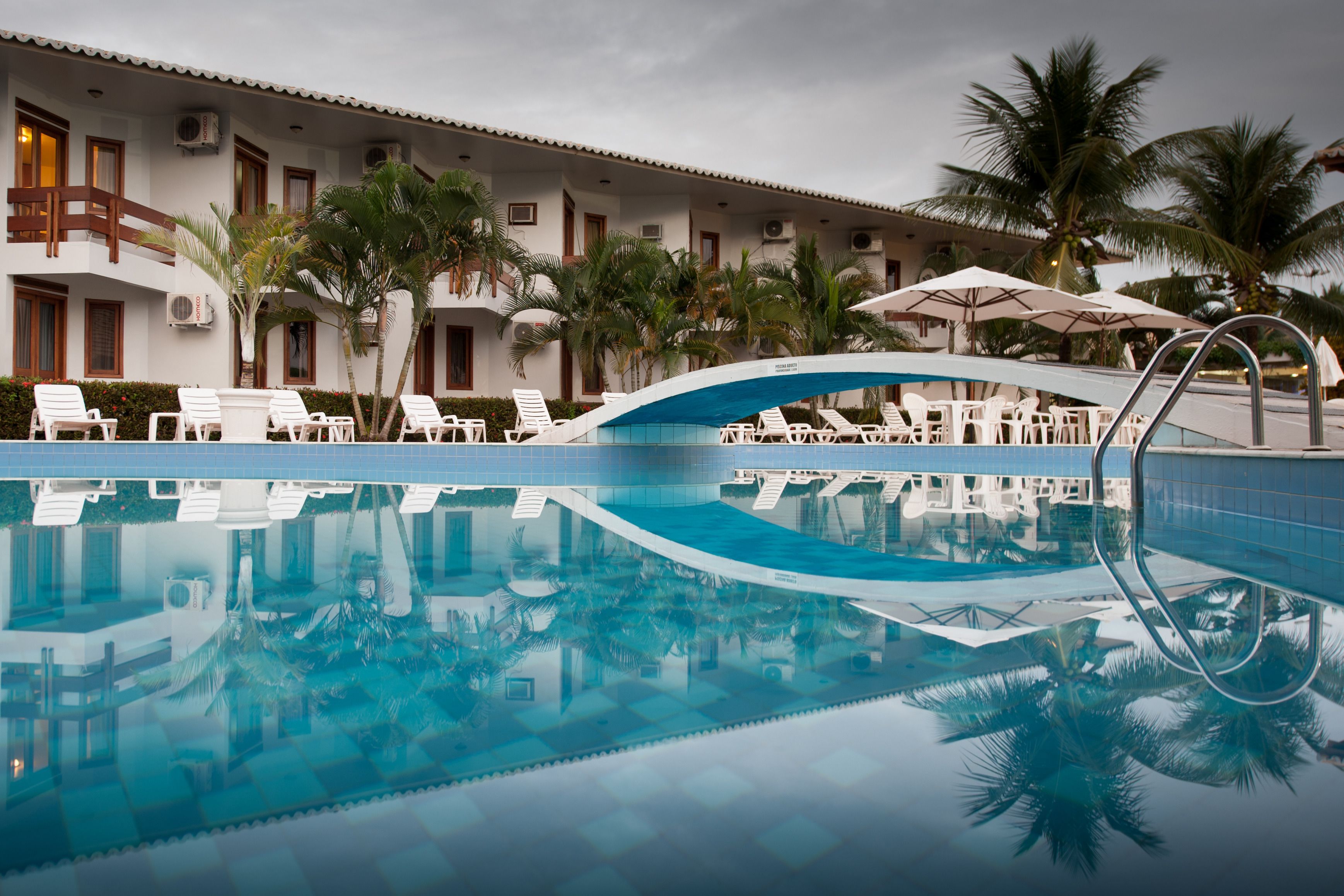 Una piscina al aire libre, sillones reclinables de piscina