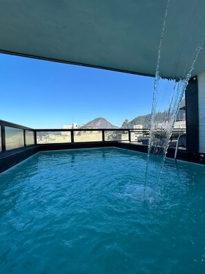 A pool with clear blue water and a view of a mountain in the background. - Real Palace Hotel (Rio de Janeiro)