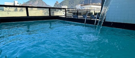 Una piscina al aire libre, tumbonas