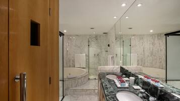 A modern bathroom with a marble vanity, a bathtub, and a large mirror.