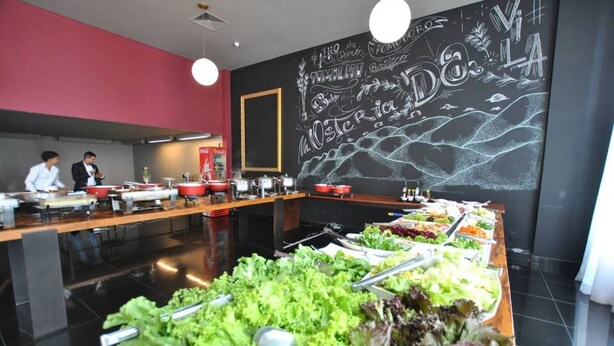 A buffet setup with various food items and a chalkboard with writing on the wall. - Piemonte Hotel (Nova Lima)