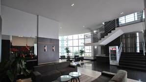 A spacious lobby with a modern staircase, seating area, and large windows. - Piemonte Hotel (Nova Lima)