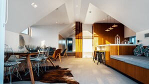 A modern interior with a dining area, a bar, and a seating area with a view. - Cremorne Point Manor (Cremorne Point)