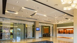 A modern lobby with a reception desk, seating area, and a decorative ceiling light fixture. - Sunway Hotel Seberang Jaya (Seberang Jaya)