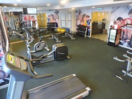 Una palestra con tapis roulant, ellittiche e pesi liberi.