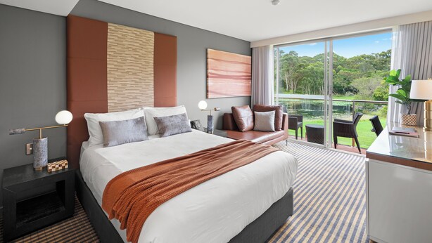 A modern hotel room with a large bed, a desk, and a balcony with a view of the outdoors. - Lakeside Hotel and Conference Centre (Macquarie Park)