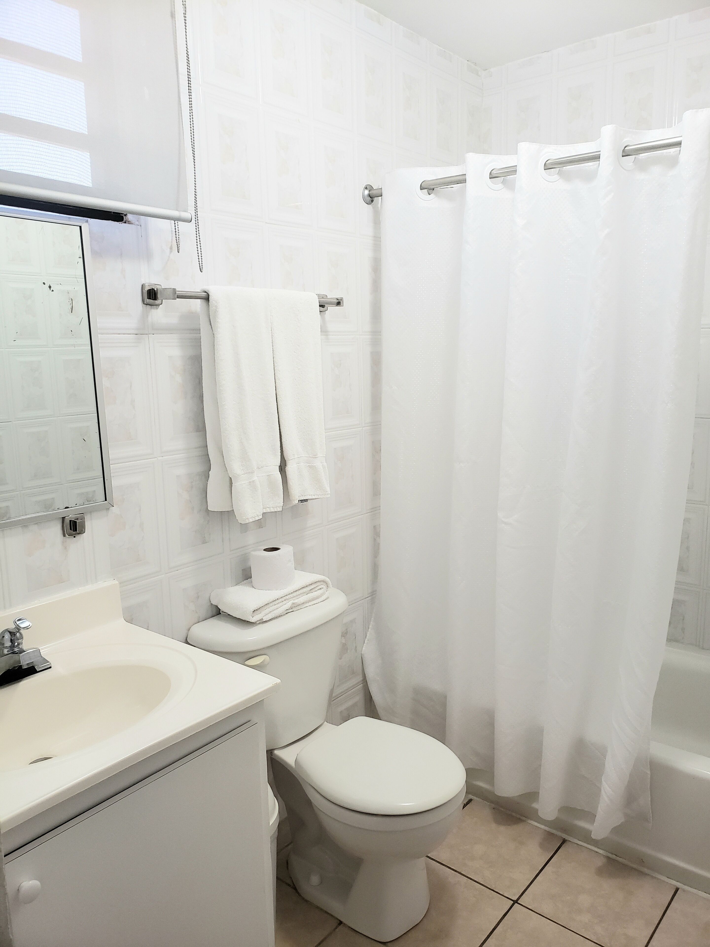 Une salle de bain avec des toilettes, un lavabo et un miroir.