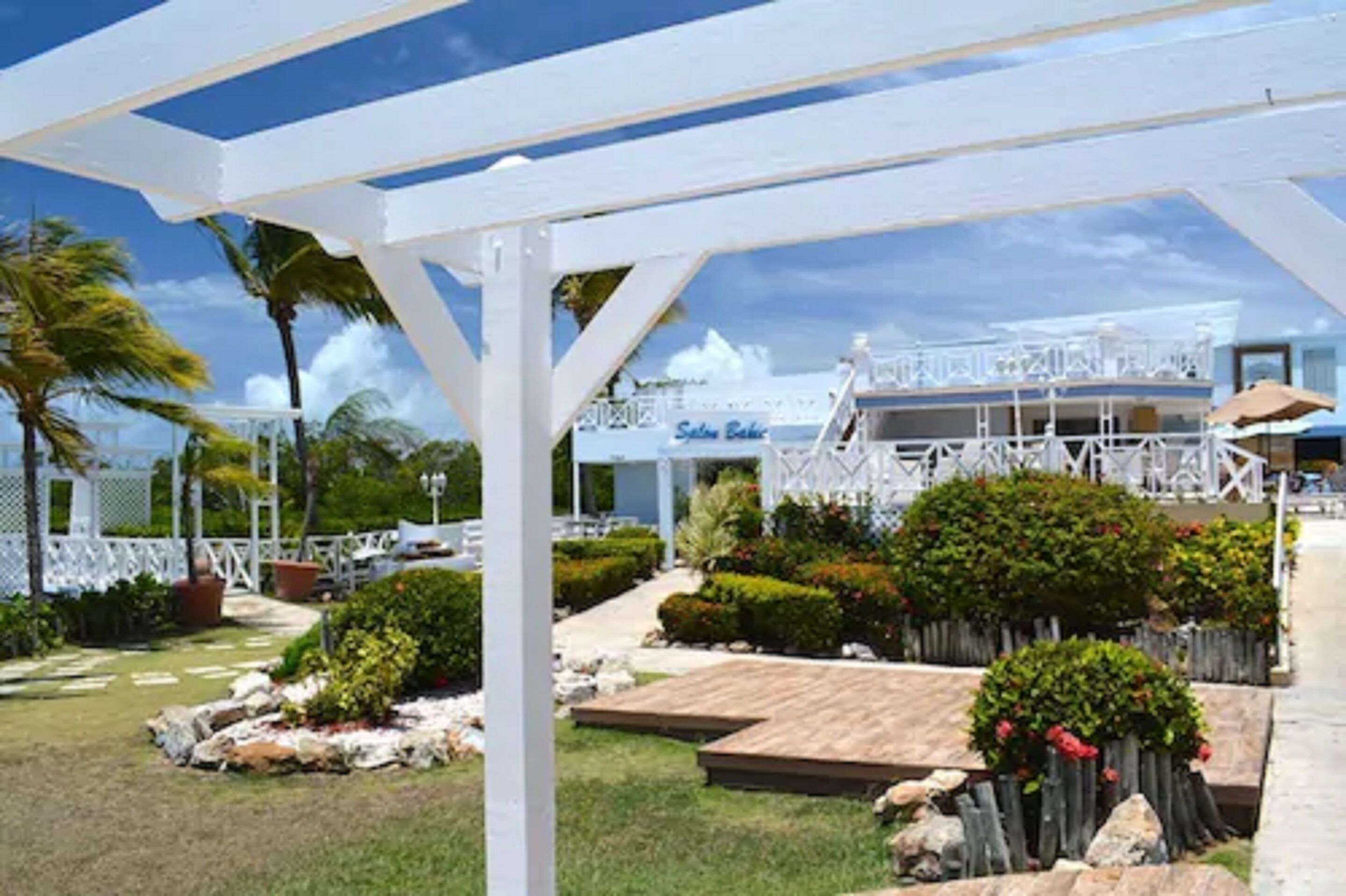Un kiosque blanc offrant une vue sur un bâtiment portant l’inscription « Sail Bar ».