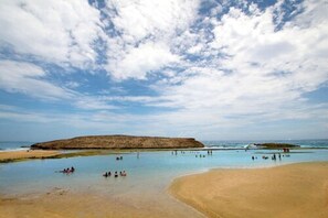 En la playa, camastros, sombrillas y toallas de playa 