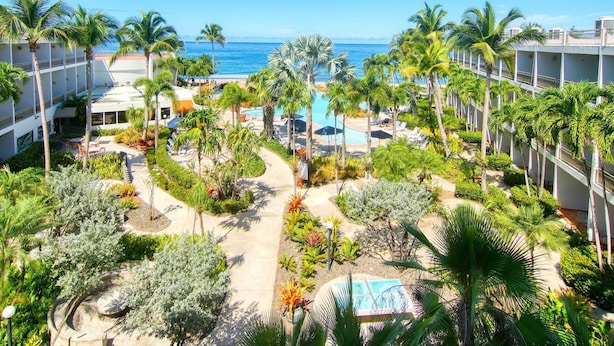 A resort with multiple swimming pools, palm trees, and a view of the ocean. - Rincon of the Seas - Grand Caribbean Hotel (Rincon)