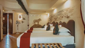 A hotel room with three beds, a standing fan, a wall mural, and a ceiling with recessed lighting.