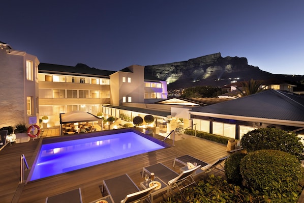 Una piscina al aire libre, tumbonas
