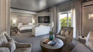 Une chambre d’hôtel moderne avec un grand lit, un canapé, une table basse et un téléviseur.