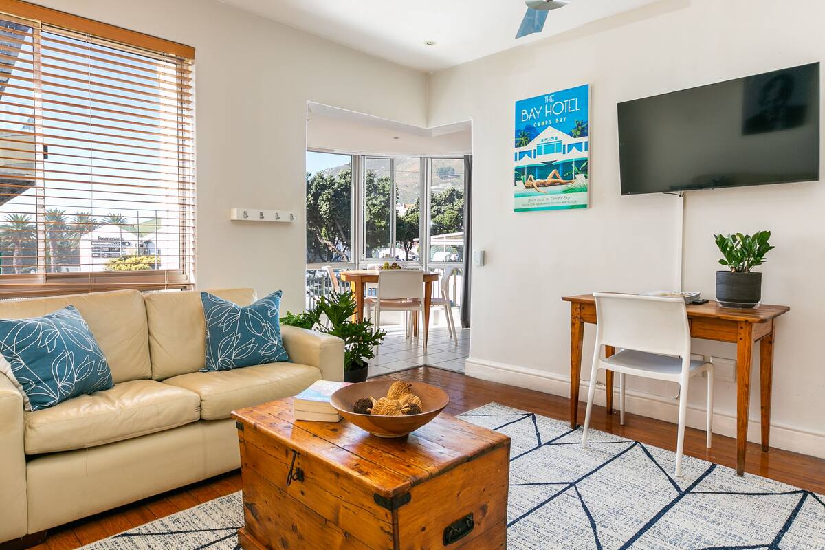 A modern living room with a beige sofa, a wooden coffee table, and a television mounted on the wall.