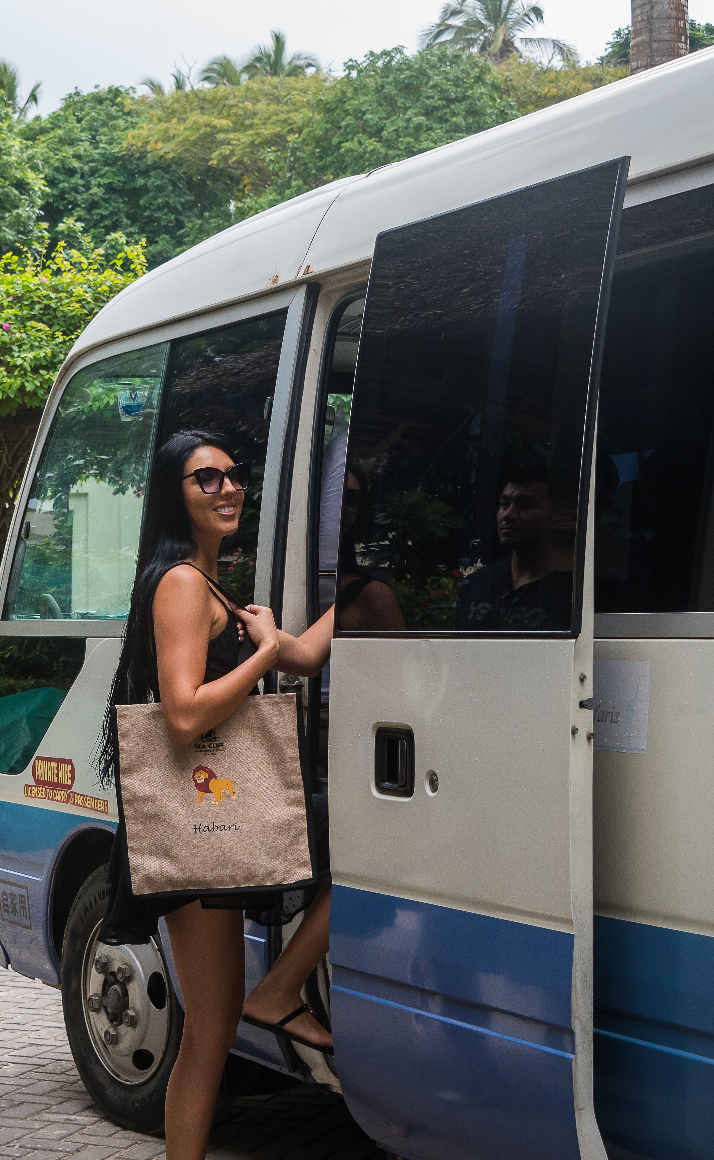 Una persona bajando de un autobús llevando una bolsa de mano grande.
