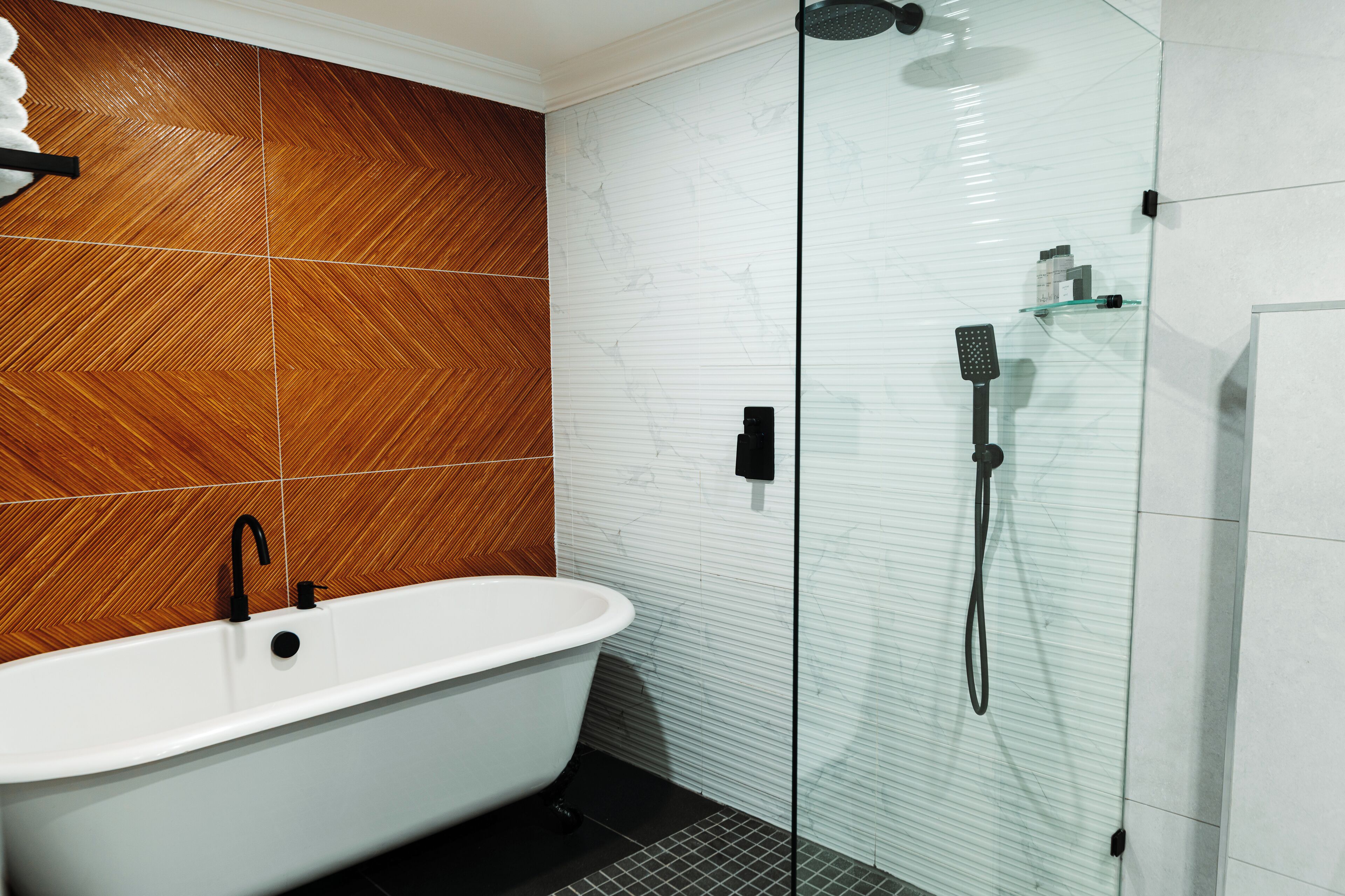 A bathroom with a freestanding bathtub, a glass-enclosed shower, and a tiled floor.