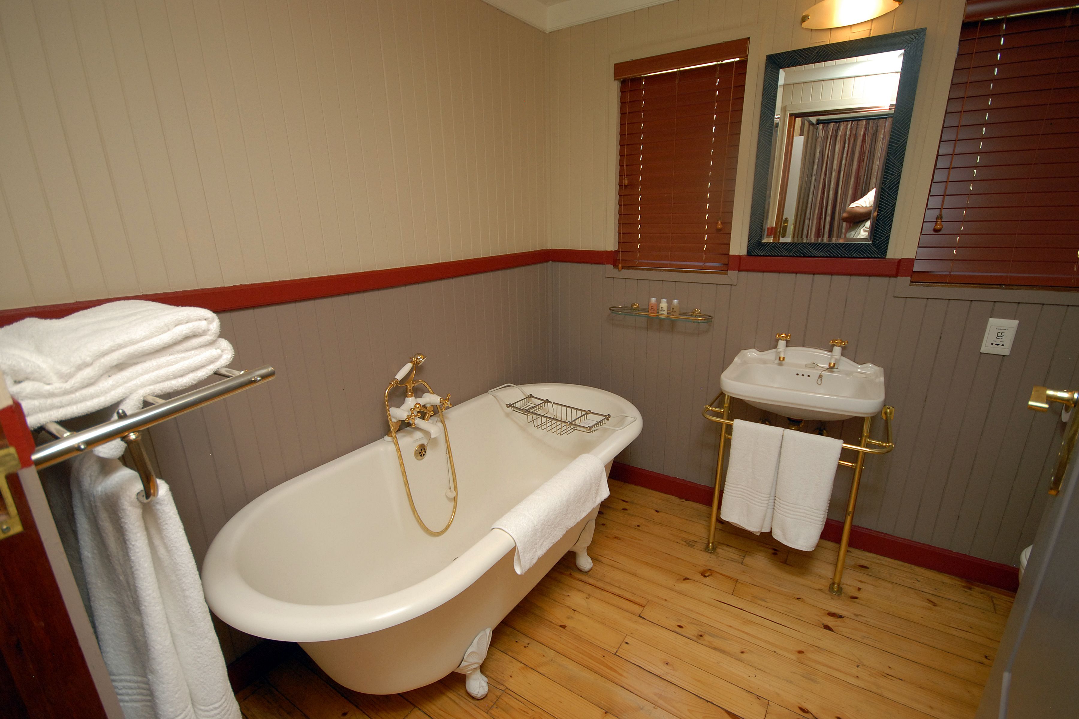 A bathroom with a freestanding bathtub, a vanity with a sink, and a mirror.