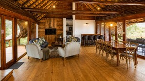 Un chalet spacieux doté d’un haut plafond en bois, d’un coin repas et d’un espace détente avec des canapés et des fauteuils.