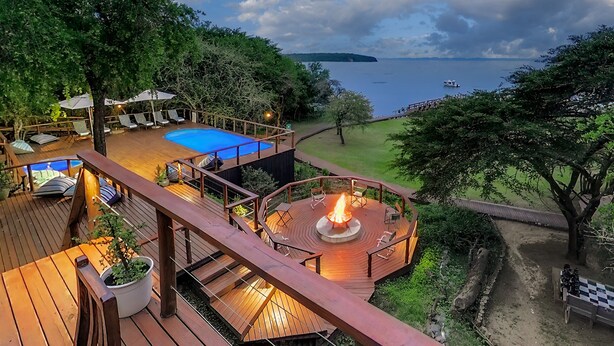 Une terrasse avec une piscine, un espace salon extérieur et un foyer.