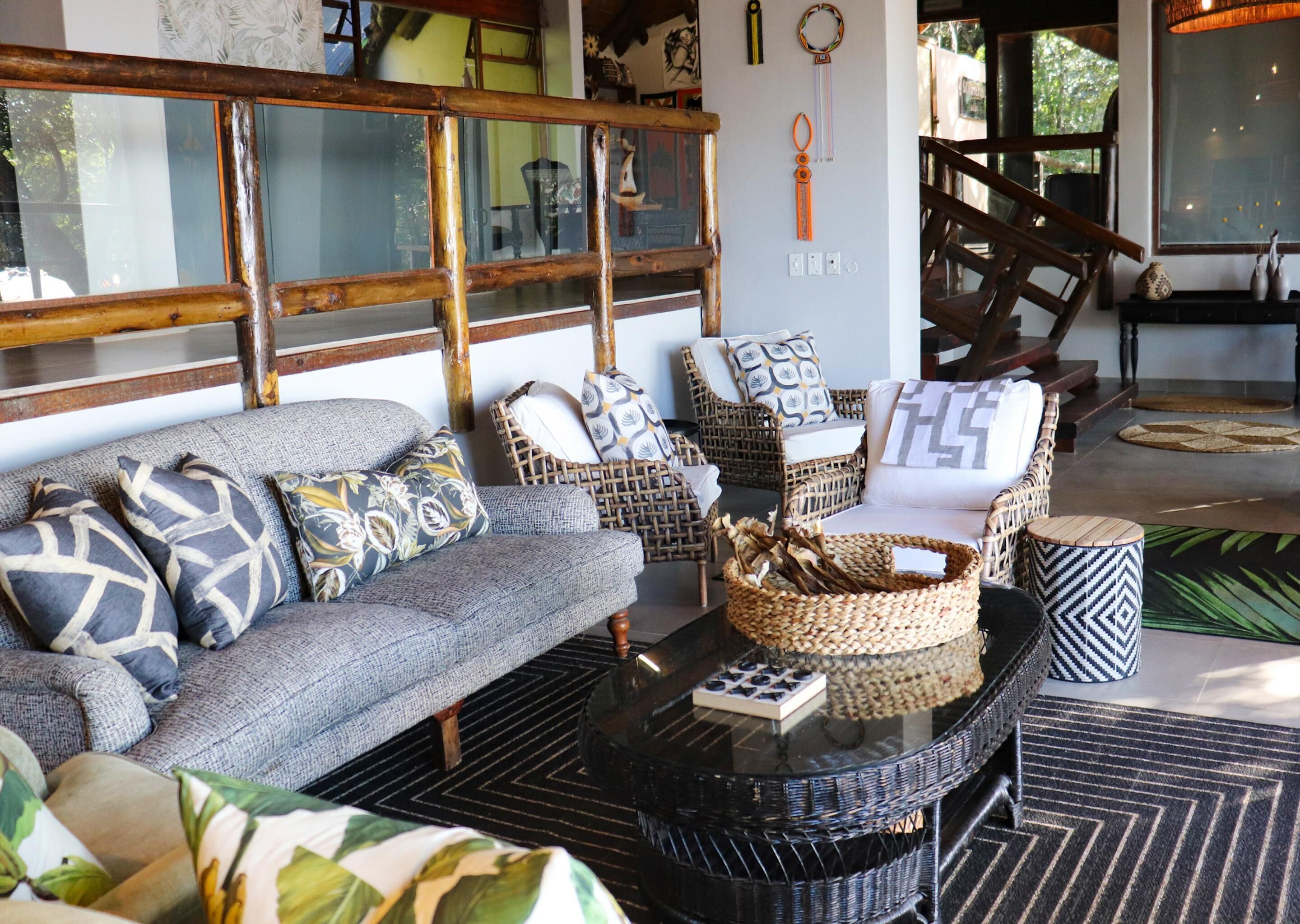 A cozy living area with a sofa, wicker chairs, a coffee table, and a fireplace.