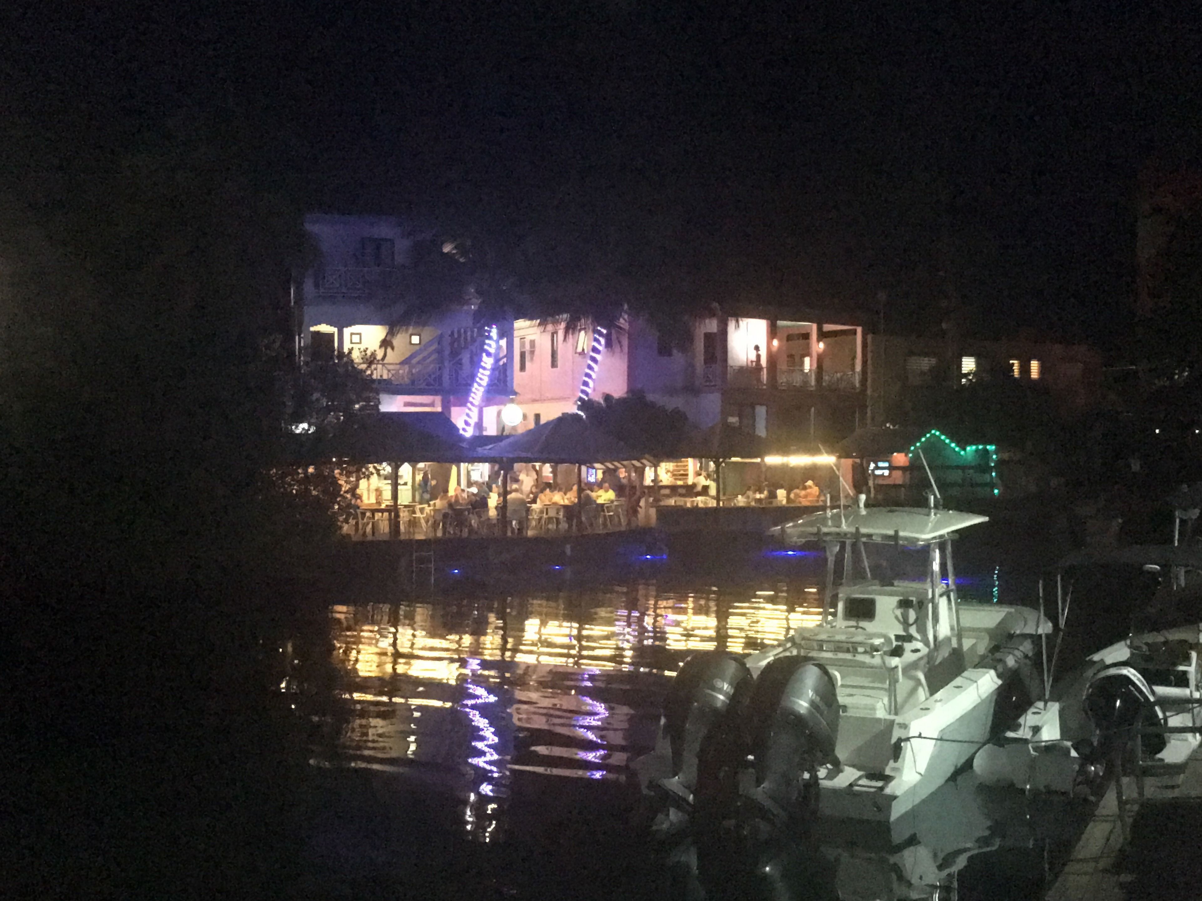 Un edificio frente al agua con un comedor y un barco amarrado cerca.