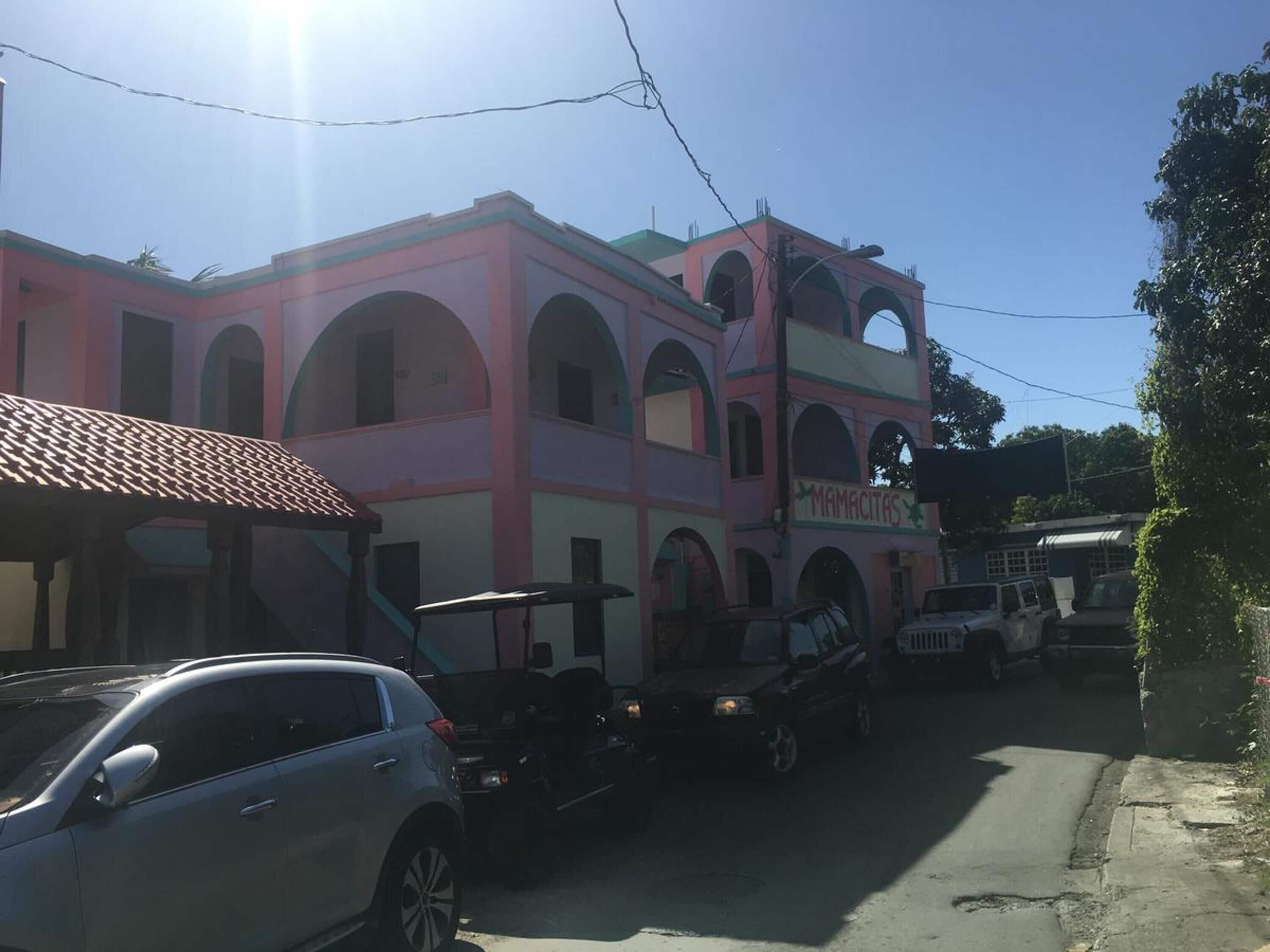 A pink building with arched windows and a sign reading "MAMACITAS".