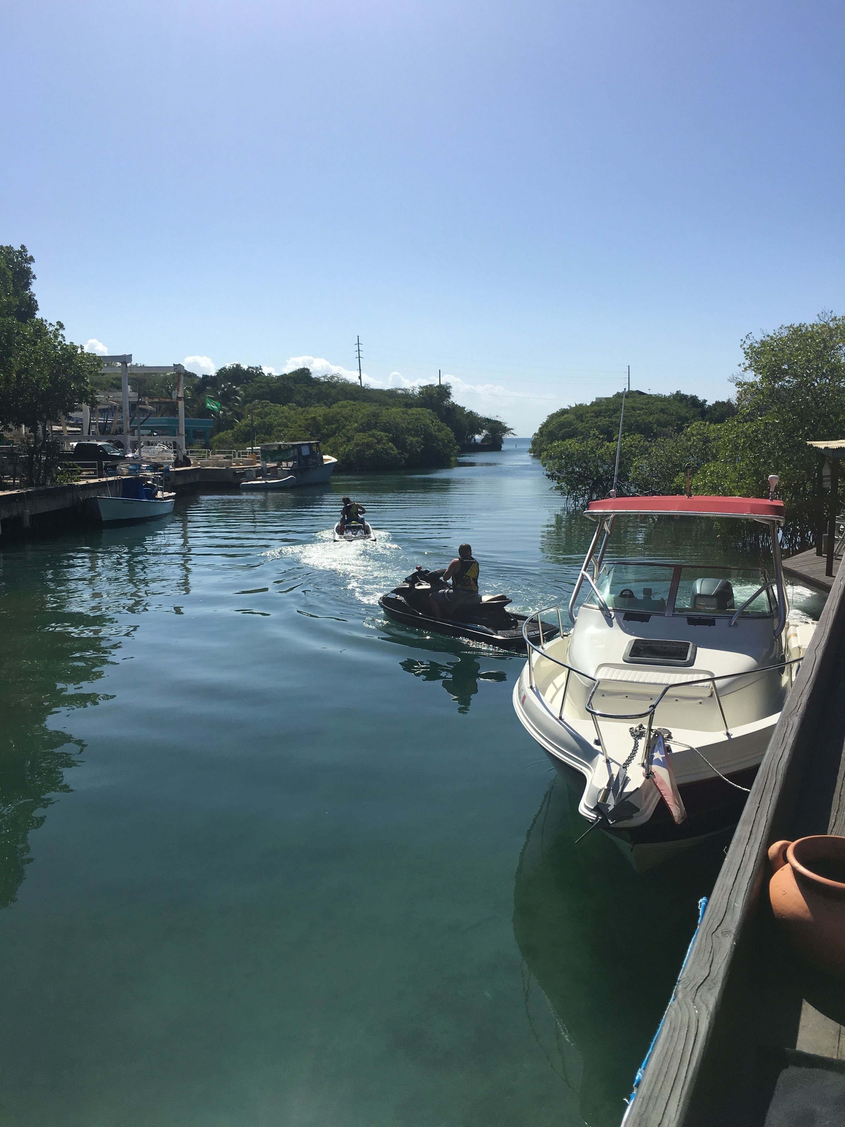Un canale tranquillo con barche e un jet ski.