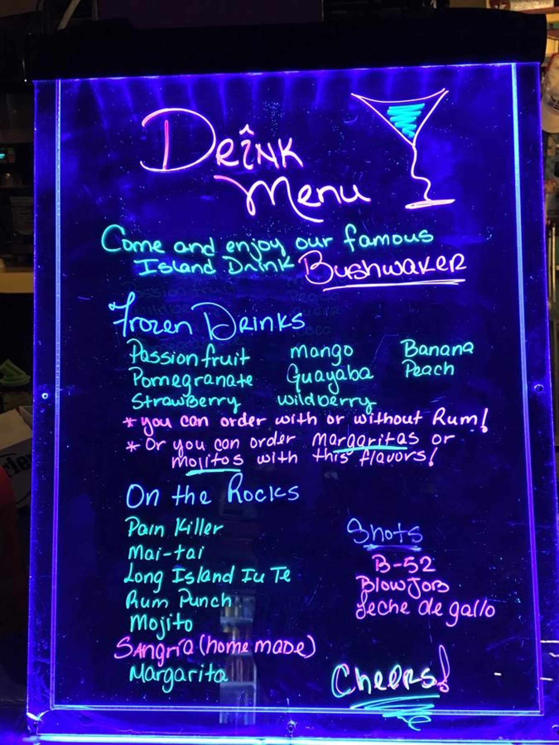 Eine Neonreklame zeigt eine Getränkekarte mit Optionen wie Maracuja, Mango und Bananen-Pfirsich.