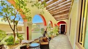 A covered outdoor seating area with wicker furniture and potted plants. - El Sueño Hotel & Spa (Puebla)