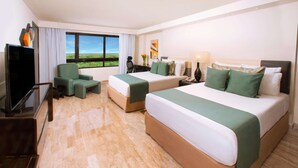 A hotel room with two beds, a desk, a chair, a TV, and a window with a view of the landscape. - Smart Cancun The Urban Oasis (Cancun)
