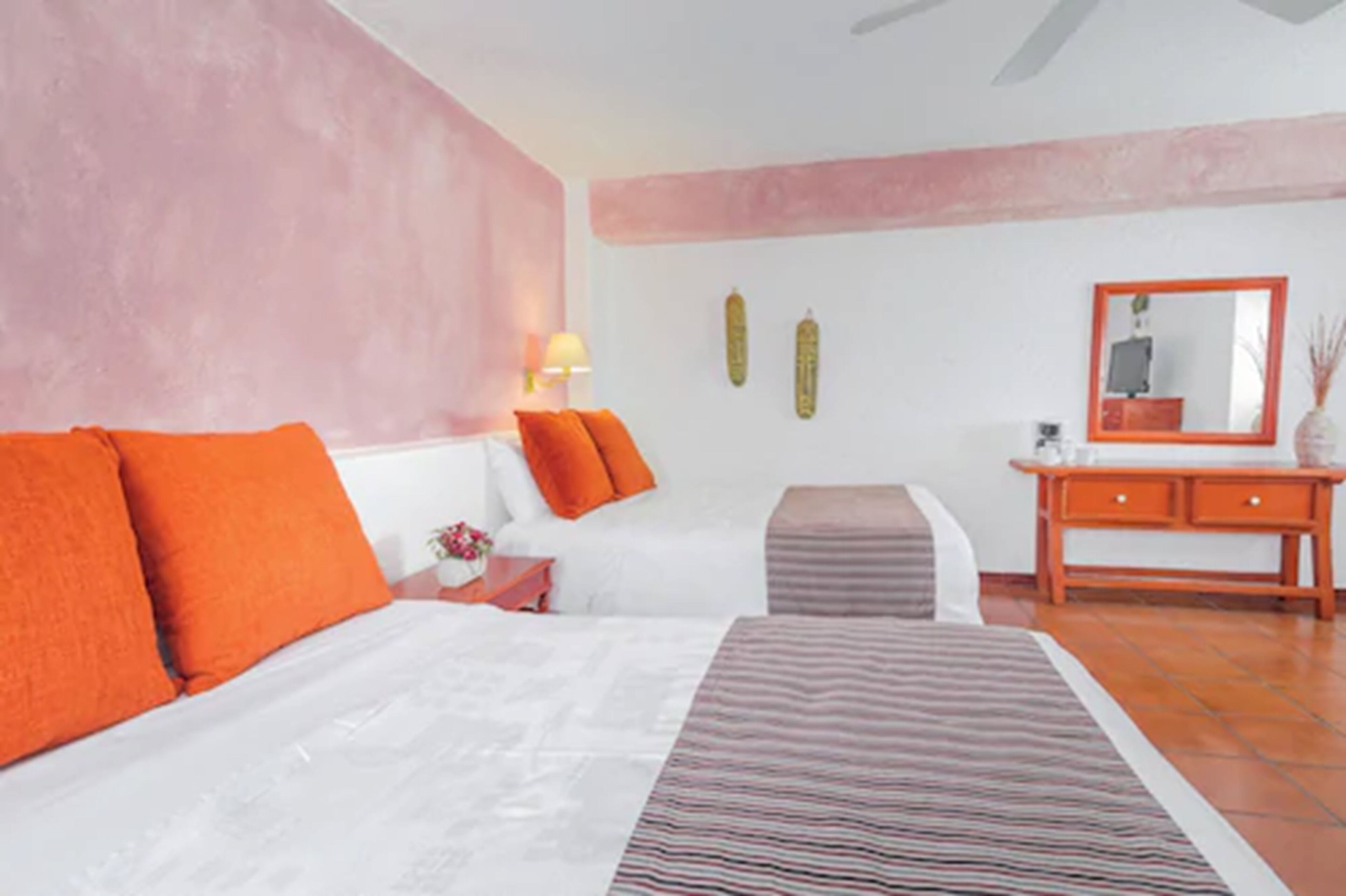 A bedroom with a bed, an ottoman, a nightstand, and a dresser.