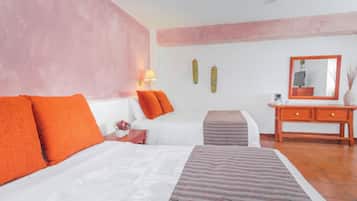 A bedroom with a bed, an ottoman, a nightstand, and a dresser.