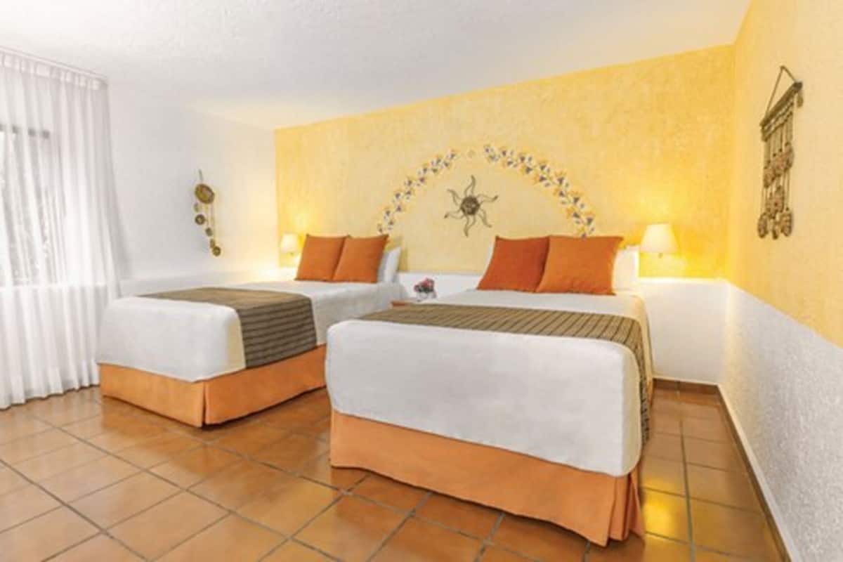 A hotel room with two beds, a decorative wall piece, and a curtain.