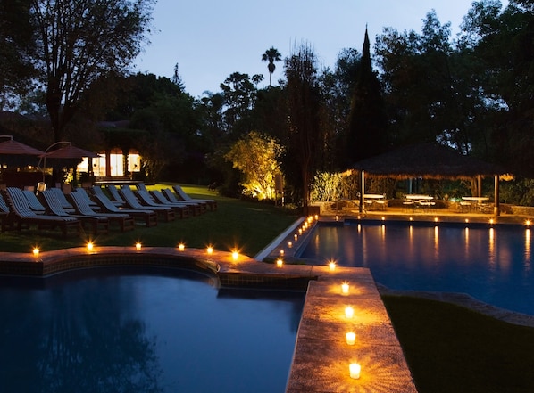 Una piscina al aire libre, sombrillas, tumbonas