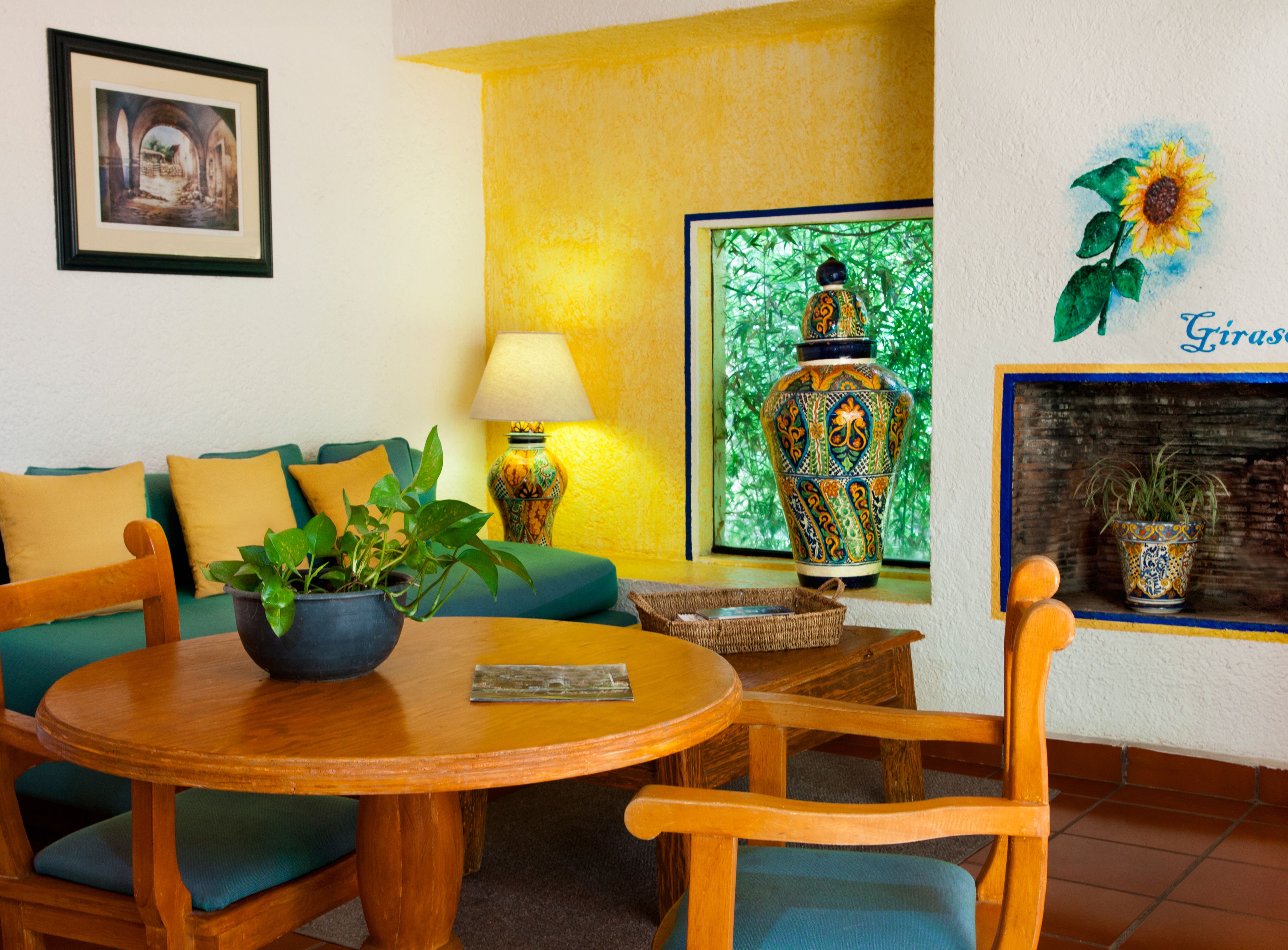 A cozy room with a green sofa, a wooden table, and a potted plant.